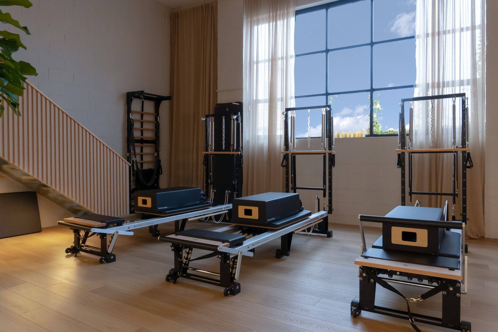 Reformers set up under tall windows at Leaside Pilates